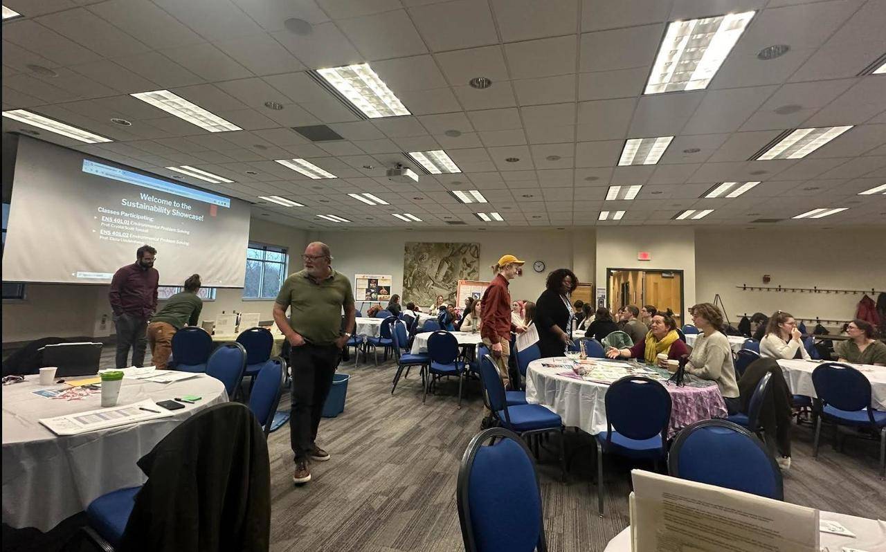 a photo of the Grand River room full of circular tables and people viewing and presenting projects and local sustainable businesses